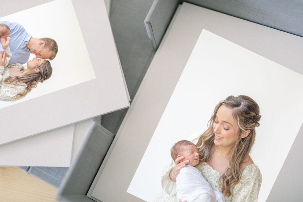 A light blue linen box holding beautiful matted prints of a lifestyle newborn session by a Raleigh Newborn Photographer. 